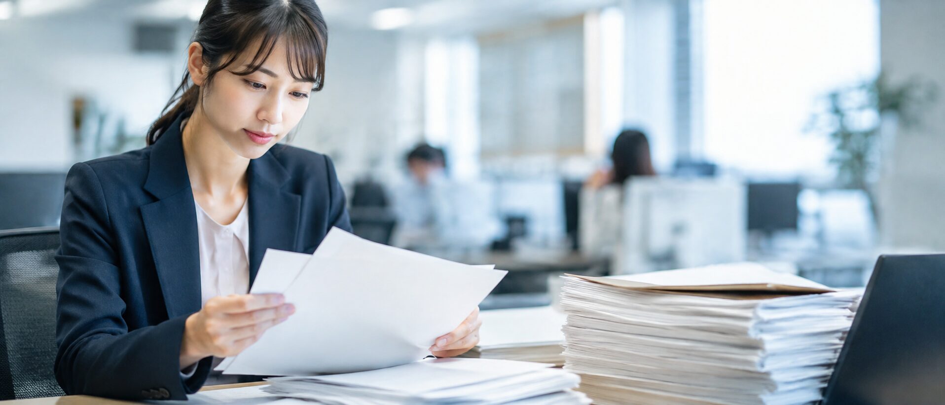 大量の紙の書類を確認しているイメージ画像